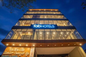 Um edifício de hotel moderno com uma placa chamativa 'fabHOTELS'.