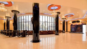A spacious lobby with high ceilings, large windows, and modern chandeliers. - Fabhotel Aqua Villa (Barasat)