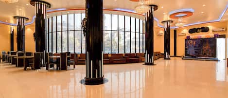 A spacious lobby with high ceilings, large windows, and modern chandeliers.
