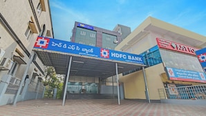 A building with a blue sign for HDFC Bank and a red sign for Just Food. - Fabhotel La Vista Inn Grand (Hyderabad)