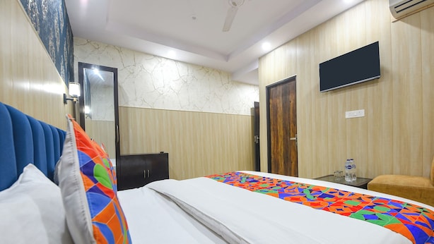 Ein Hotelzimmer mit Bett, Schreibtisch, Stuhl, Fernseher und einer Wasserflasche.