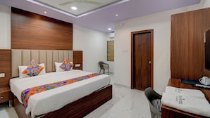 Une chambre à coucher moderne, comprenant un lit, des tables de chevet, une chaise, une armoire et un ventilateur de plafond.