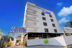 A multi-story building with a sign for 'fab HOTELS' and 'RELAX INN EXECUTIVE' indicating it offers various room types including AC, non-AC, and deluxe rooms. - Fabhotel Relax Inn Executive (Pune)