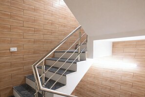 A modern staircase with metal railings and wooden wall panels. - Fabhotel Zen Stay (New Delhi)