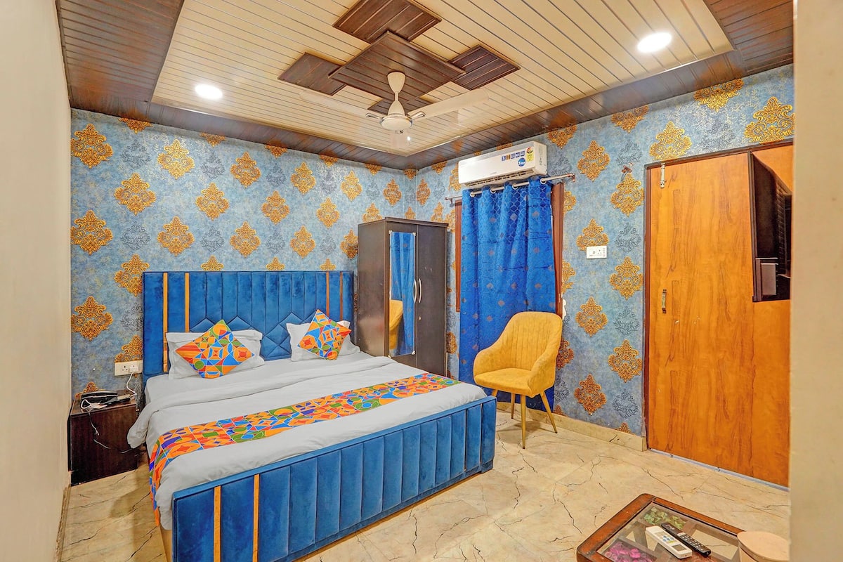 Un dormitorio con cama, armario, silla y aire acondicionado.