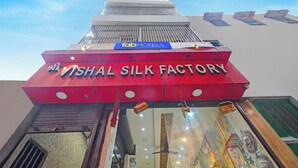 A building with a sign for 'Vishal Silk Factory' and a 'FabHotels' sign above it. - Fabhotel Vishal Residency (Varanasi)
