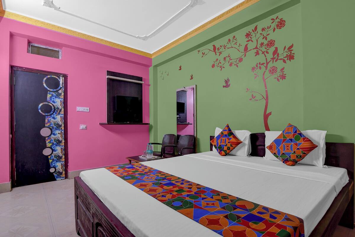 Habitación de hotel con cama, escritorio y silla. Cuenta con una ventana y una puerta.