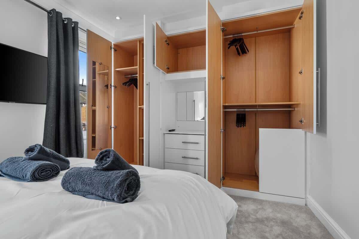 Ein Hotelzimmer mit einem Bett, einem Kleiderschrank, einem Spiegel und einem weißen Schrank.