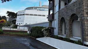 A building with a restaurant named 'ThalassoTherapie' and a bar, featuring a stone facade and multiple balconies. - Apartment Arzon - 1 bedroom and terrace (Arzon)