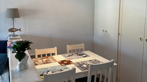 A dining area with a white table, four chairs, a lamp, and a plant. - Apartment Arzon - 1 bedroom and terrace (Arzon)