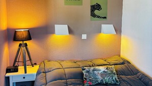 A bedroom with a bed, a desk with a lamp, and motivational posters on the wall. - Apartment Arzon - 1 bedroom and terrace (Arzon)