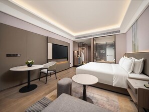 A modern hotel room with a large bed, a desk, a chair, and a TV. - Holiday Inn Nantong Rudong by IHG (Nantong)