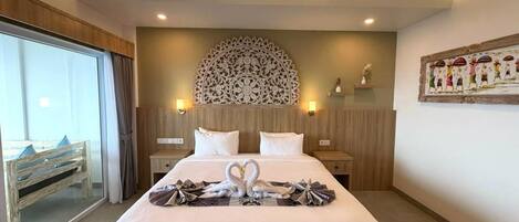 A hotel room with a large bed, two bedside tables, a decorative wall piece, and a painting on the wall.