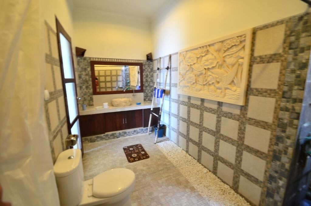 Une salle de bain avec des toilettes, un lavabo et un miroir.