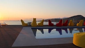 A poolside area with yellow and red bean bag chairs, a clear view of the sea, and a wooden deck. - Hotel Porta Ksamil (Ksamil)