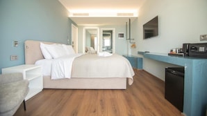 A modern hotel room with a bed, a desk, a chair, a TV, and a microwave. - Hotel Porta Ksamil (Ksamil)