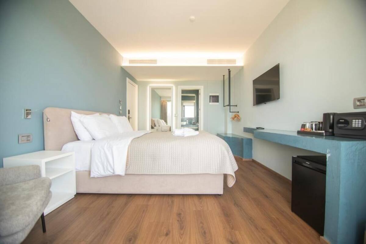 Una habitación de hotel moderna con cama, escritorio, silla, televisor y microondas.