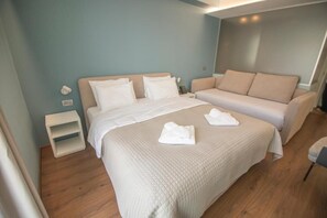A hotel room with a large bed, a smaller bed, a sofa, and a nightstand. - Hotel Porta Ksamil (Ksamil)