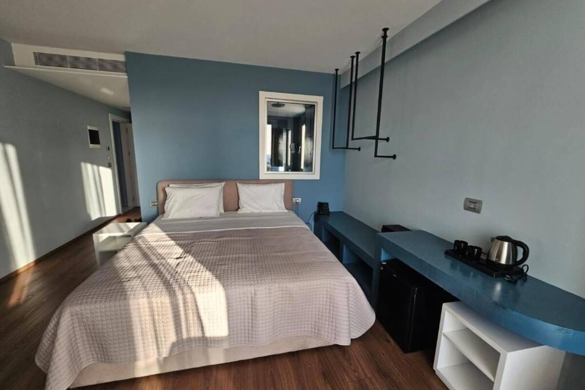 Un dormitorio con cama, escritorio y ventana.