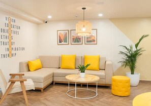 Una sala de estar moderna con un sofá, una mesa de centro redonda y una planta en maceta.
