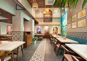 Un interior de restaurante con cabinas, mesas y un suelo estampado.