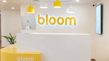 A reception desk with the word 'bloom' prominently displayed above it.