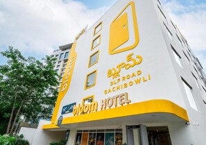 A hotel with a modern facade, featuring a prominent logo and name in large letters.