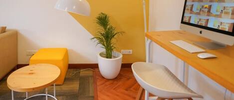 Un espace de bureau moderne comprenant un bureau, un ordinateur, une chaise, une lampe et une plante en pot.