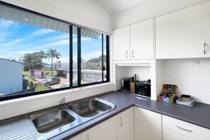 Fridge, microwave, oven, stovetop - Beachside 3-Bed Apartment with Garage Parking (Batehaven)