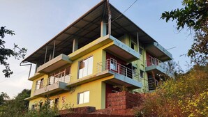 A multi-story building with a flat roof and balconies. - Red Soil Strawberry Farm villa (Bhuteghar)