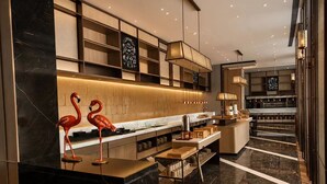 A modern kitchen with marble countertops, wooden shelves, and a central island. - voco Beijing Temple of Heaven by IHG (Beijing)