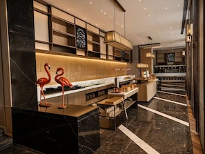 A modern kitchen with marble countertops, wooden shelves, and a central island. - voco Beijing Temple of Heaven by IHG (Beijing)