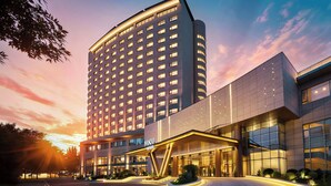 A modern hotel with a prominent entrance, multiple floors, and a well-lit facade. - voco Beijing Temple of Heaven by IHG (Beijing)