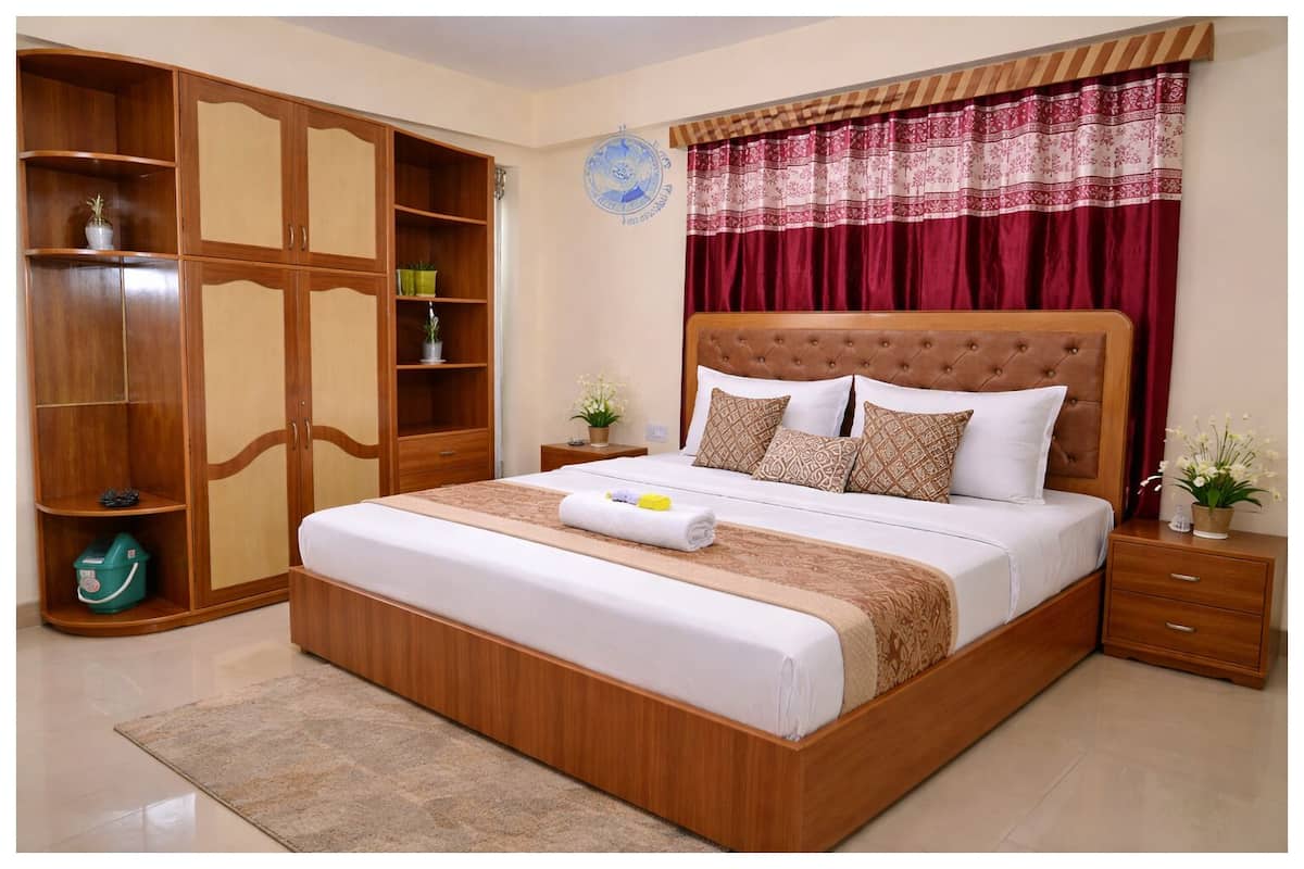 Ein Schlafzimmer mit einem großen Bett, einem Holzschrank und einer Wanddekoration.