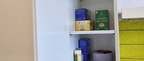 Una cocina con un refrigerador blanco, una cafetera y varios utensilios de cocina sobre la encimera.