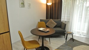 Una sala de estar moderna con un sofá, dos sillones, una mesita y una lámpara.