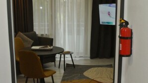 Habitación de hotel con comedor, extintor y televisor.