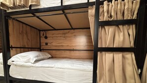 A bunk bed with a wooden headboard, a white mattress, and beige curtains. - Halo.Hostel (Bishkek)