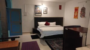 Quarto com cama, mesa de cabeceira e escrivaninha.