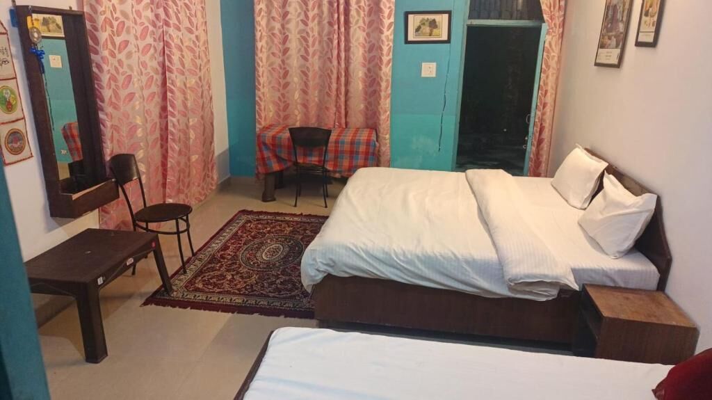 Un dormitorio con cama, escritorio, silla y una pequeña mesa.