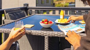 Ett matbord med en skål med frukt, en flaska och ett glas apelsinjuice.