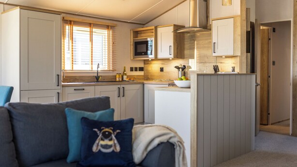 Une cuisine moderne avec des meubles blancs, un four à micro-ondes et un évier.