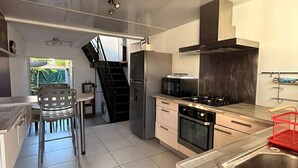Una cocina moderna con una isla central, electrodomésticos de acero inoxidable y vistas al exterior.