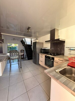 A modern kitchen with a central island, stainless steel appliances, and a view of the outdoors. - Sea view and balcony - Ideal house in La Saline Les Bains (Saint-Paul)