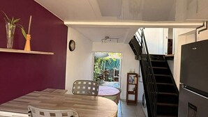 Cocina compacta con comedor, escalera y vistas al exterior.