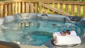 A hot tub with a wooden deck, a towel, and sunglasses on the edge. - Safari Tent sleeps 6 Pet Friendly (Hayle)
