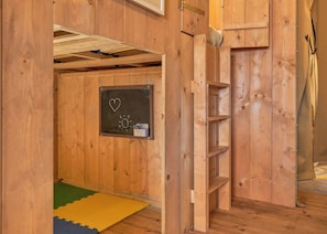 A wooden room with a chalkboard, a heart drawing, and a sun drawing.
