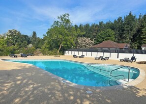 A swimming pool with lounge chairs, surrounded by trees and a fence. - Standard 2 Bedroom sleeps 6 Pet Friendly (Hayle)