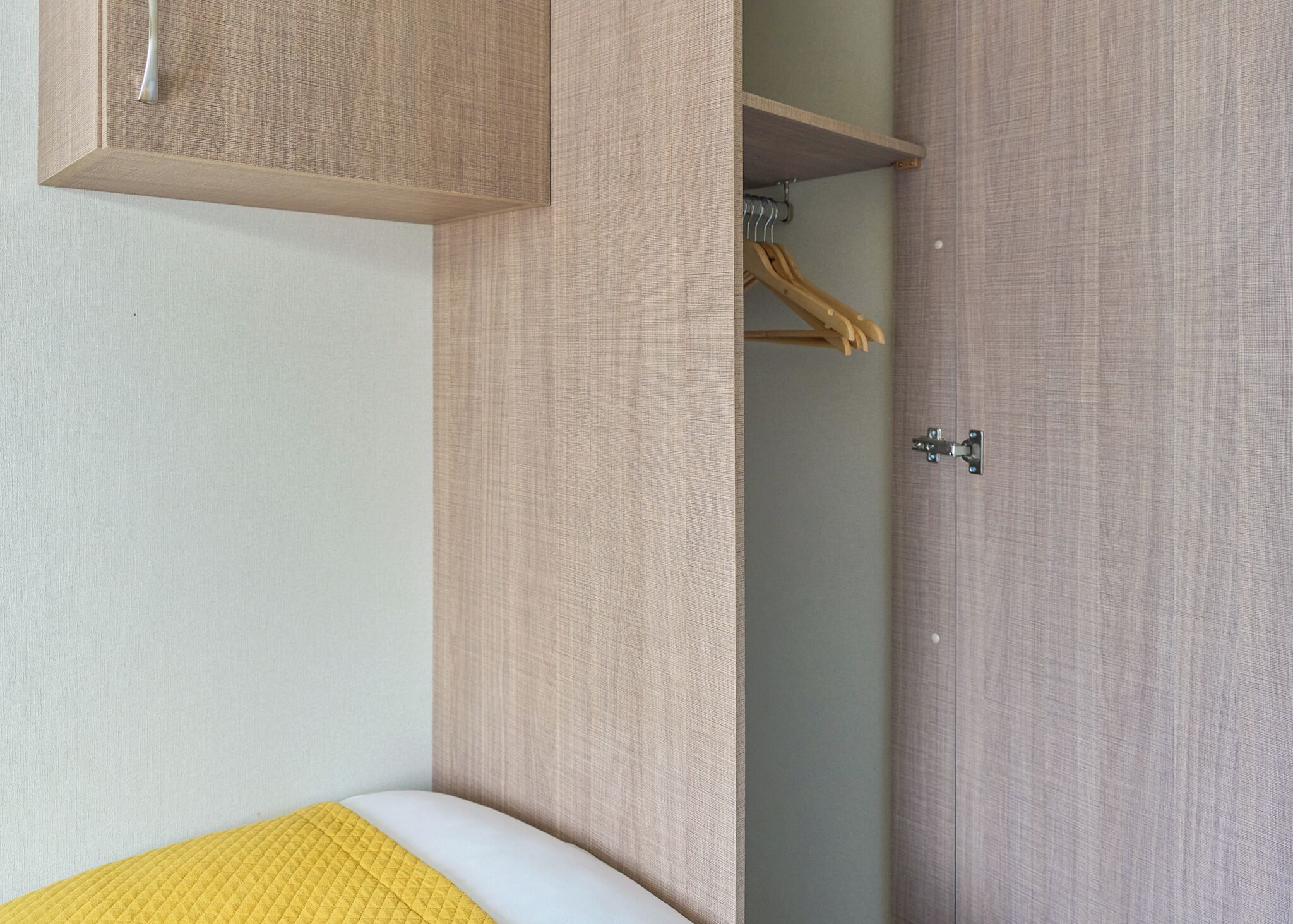 A bedroom with a bed, a wardrobe, and a door.