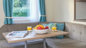 A cozy corner with a table, a bowl of fruit, and two glasses of orange juice. - Standard 2 Bedroom sleeps 6 Pet Friendly (Hayle)